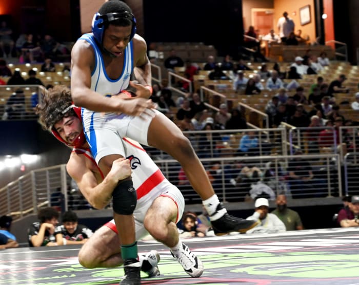 Christian Vazquez of Doral Academy gets a 7-2 win against Adaias Ortiz from Osceola during the 113-pound championship match on Saturday at the Knockout Christmas Classic at Silver Spurs Arena in Kissimmee.